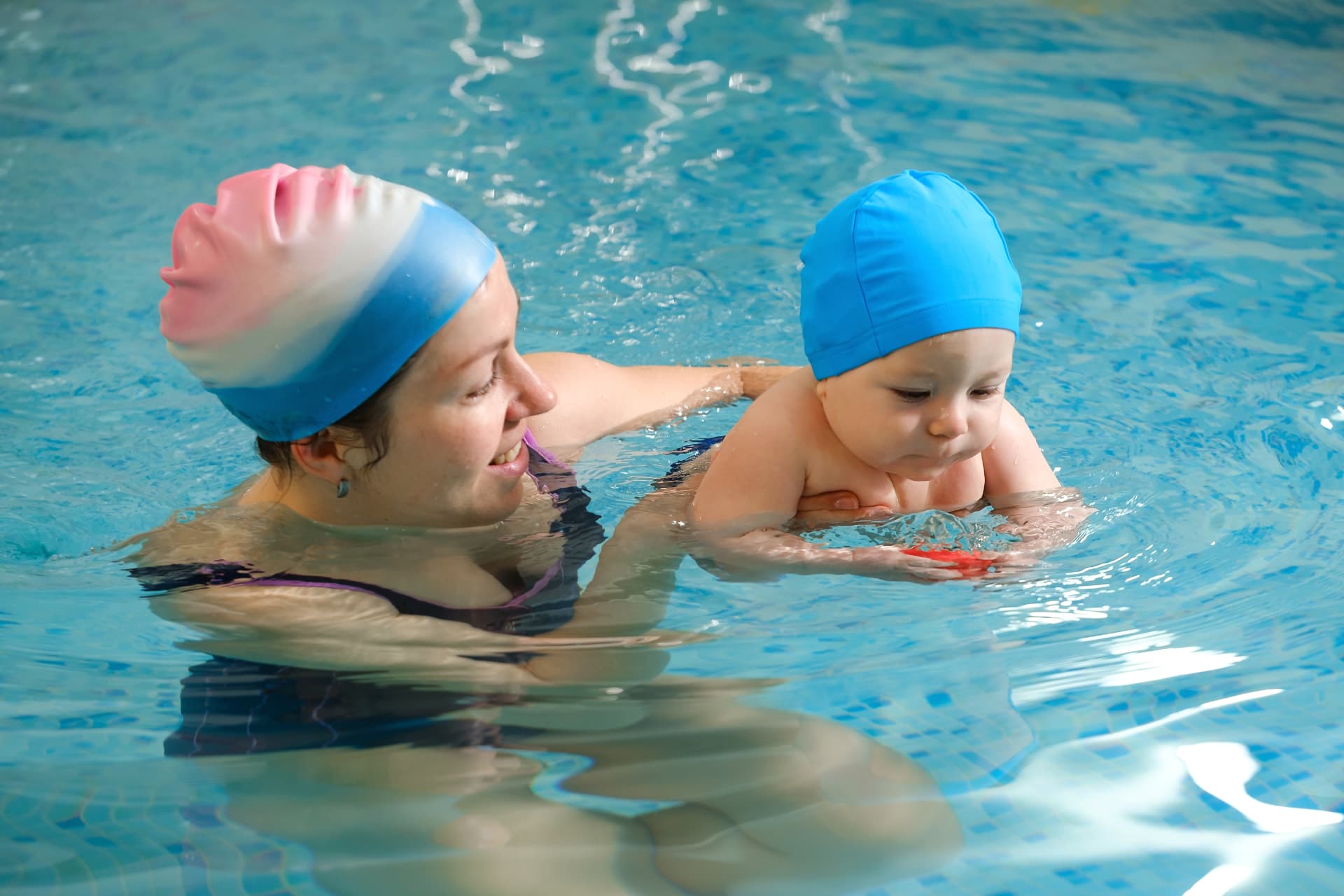 Parent and baby swim lesson in an indoor pool